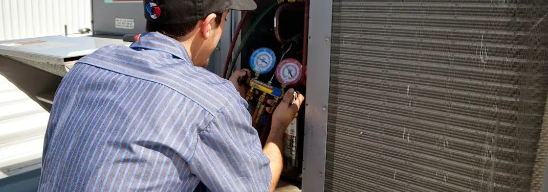 HVAC technician servicing a condenser unit in Potomac Park